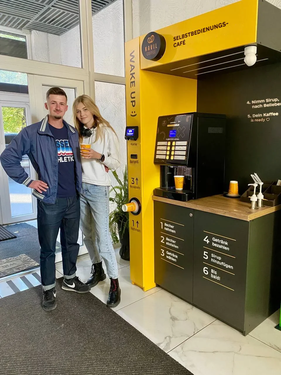 Oleksandr, Kavil-Partner, mit Kaffee vor seinem Selbstbedienungs-Café